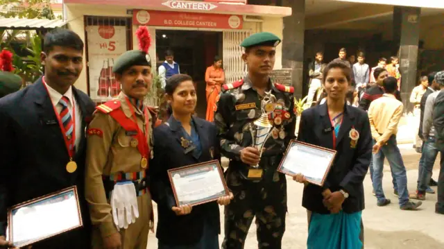 Students at an award ceremony with medals and certificates
